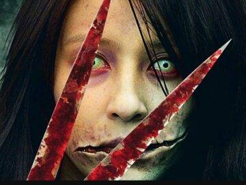 Kuchisake-onna aus dem Film "Carved: The slit mouthed woman", eine blutige Schwere vor ihr geisterhaftes Gesicht haltend.